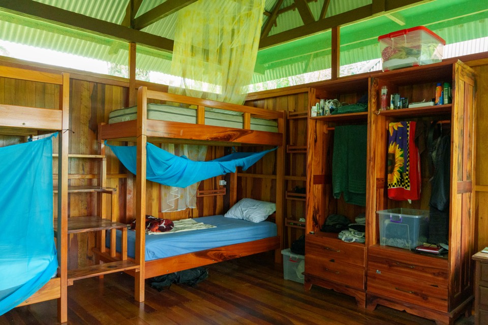 Bunk beds with mosquito nets and a wooden wardrobe